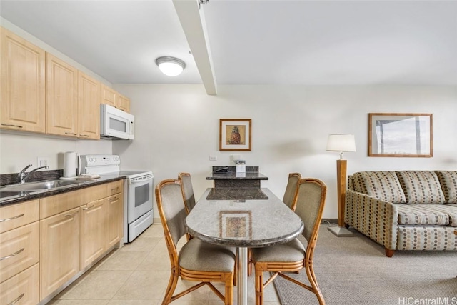 kitchen with sink, light tile patterned floors, light brown cabinetry, and white appliances