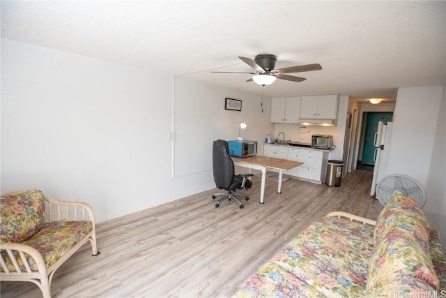 home office with ceiling fan, a textured ceiling, and light hardwood / wood-style floors