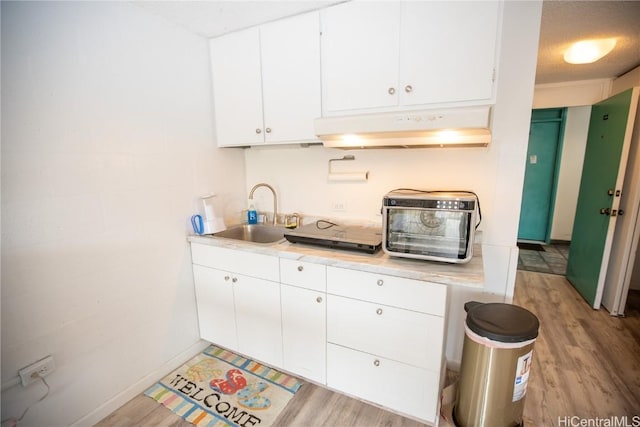 kitchen featuring sink, white cabinets, and light hardwood / wood-style floors