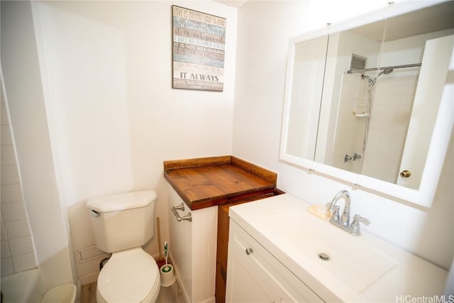 bathroom featuring vanity, toilet, and a tile shower