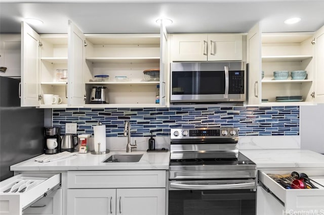 kitchen featuring white cabinetry, sink, decorative backsplash, and stainless steel appliances