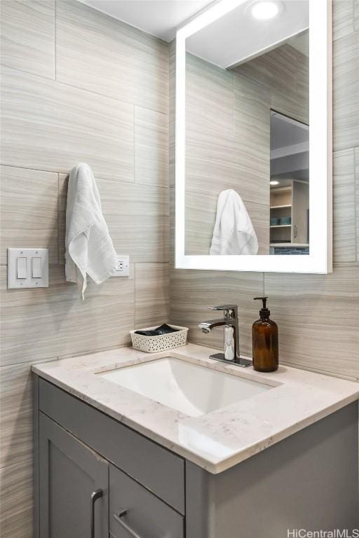 bathroom with vanity and tile walls