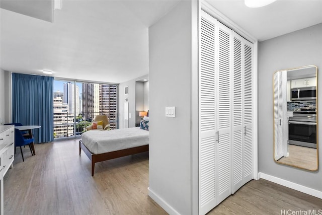 bedroom featuring expansive windows and hardwood / wood-style floors