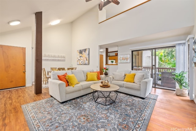 living room with hardwood / wood-style floors, high vaulted ceiling, and ceiling fan