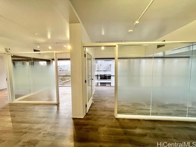 bathroom with rail lighting and hardwood / wood-style floors