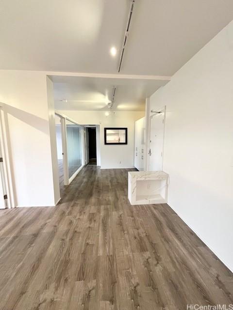 interior space featuring dark wood-type flooring and track lighting