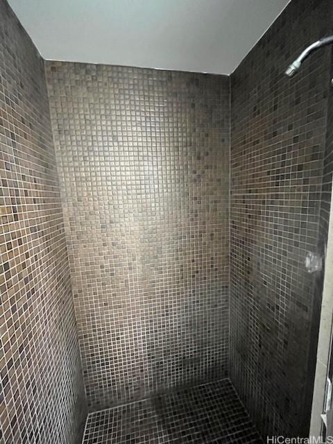 bathroom featuring a tile shower and tile walls