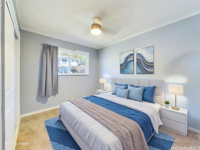 bedroom featuring light carpet, ornamental molding, and ceiling fan