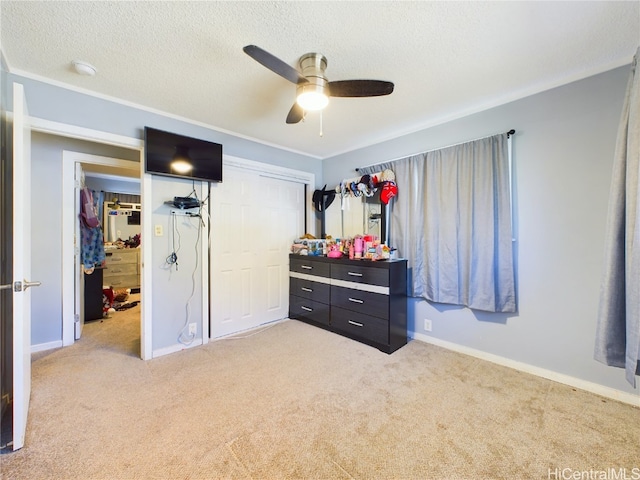 carpeted bedroom featuring ceiling fan, a textured ceiling, and a closet