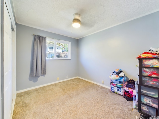 playroom featuring light carpet, ceiling fan, crown molding, and a textured ceiling