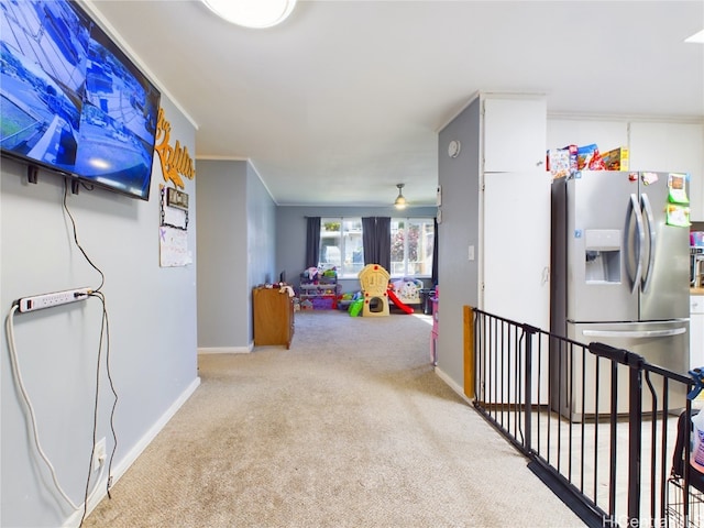 hallway featuring crown molding and light carpet