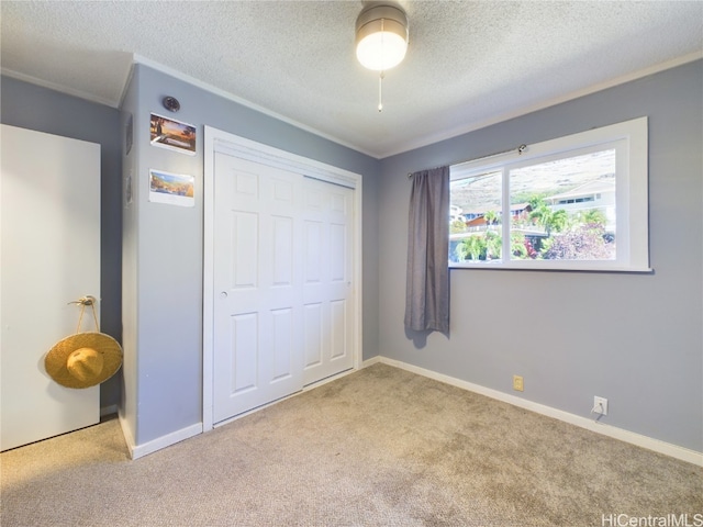 unfurnished bedroom with ceiling fan, light colored carpet, a closet, and a textured ceiling