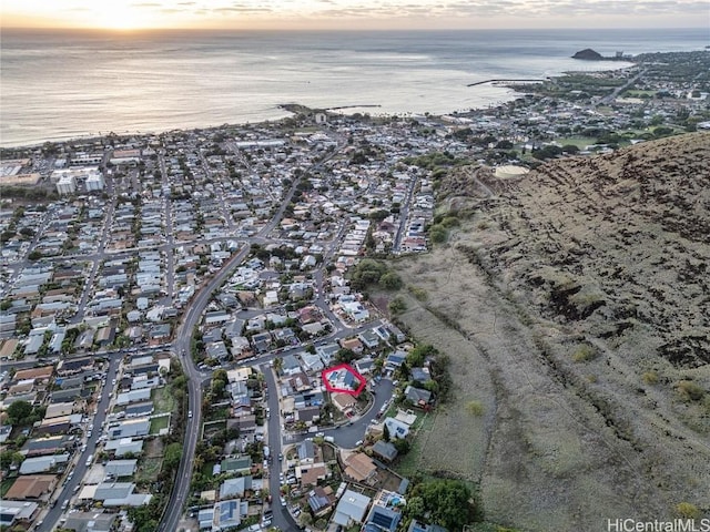 aerial view at dusk featuring a water view