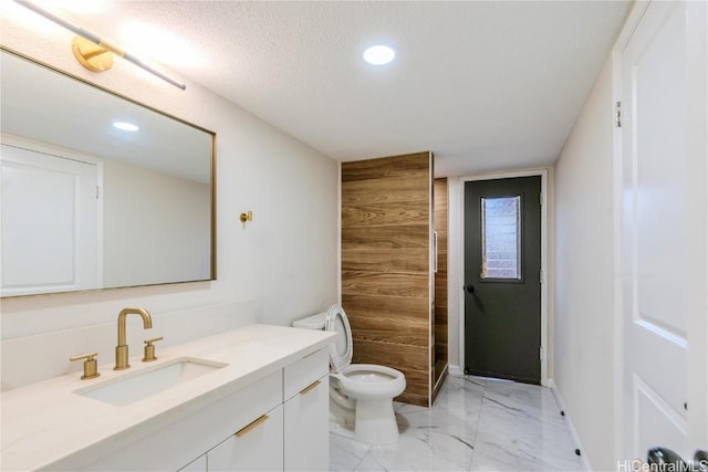 bathroom with walk in shower, vanity, toilet, and a textured ceiling