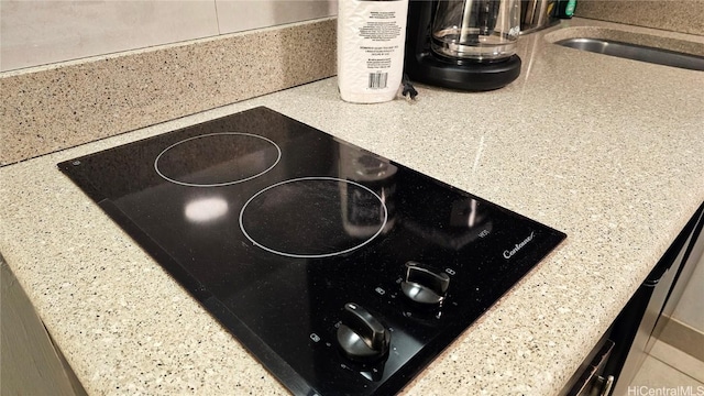 details with black electric stovetop and sink