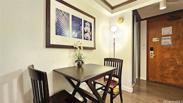 dining space featuring crown molding and dark hardwood / wood-style flooring