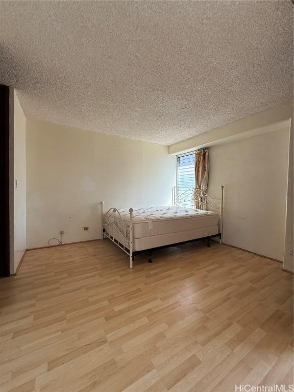 unfurnished bedroom featuring a textured ceiling and light wood-type flooring