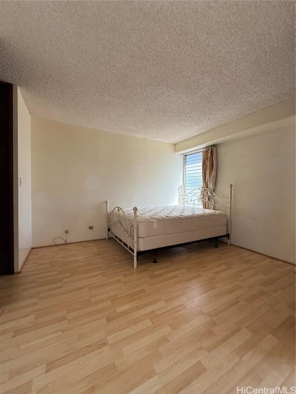 unfurnished bedroom featuring a textured ceiling and light wood-type flooring