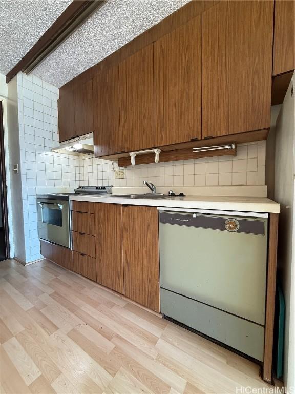 kitchen with stainless steel electric range oven, tasteful backsplash, dishwashing machine, beam ceiling, and light wood-type flooring