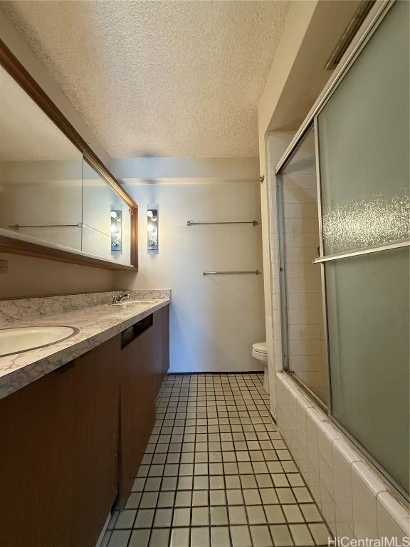 bathroom with vanity, tile patterned floors, a textured ceiling, and toilet