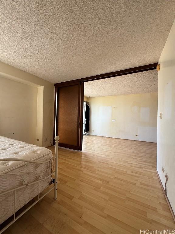 unfurnished bedroom featuring light hardwood / wood-style floors and a textured ceiling