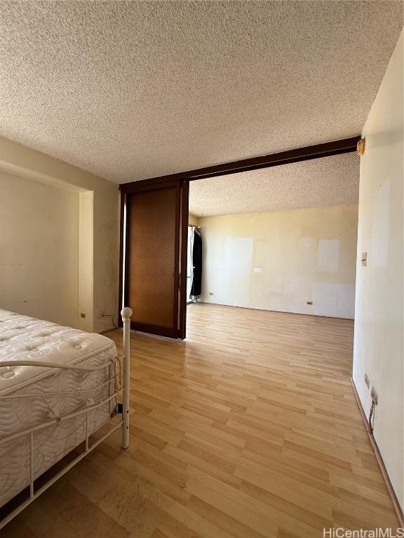 unfurnished bedroom featuring a textured ceiling and light hardwood / wood-style floors