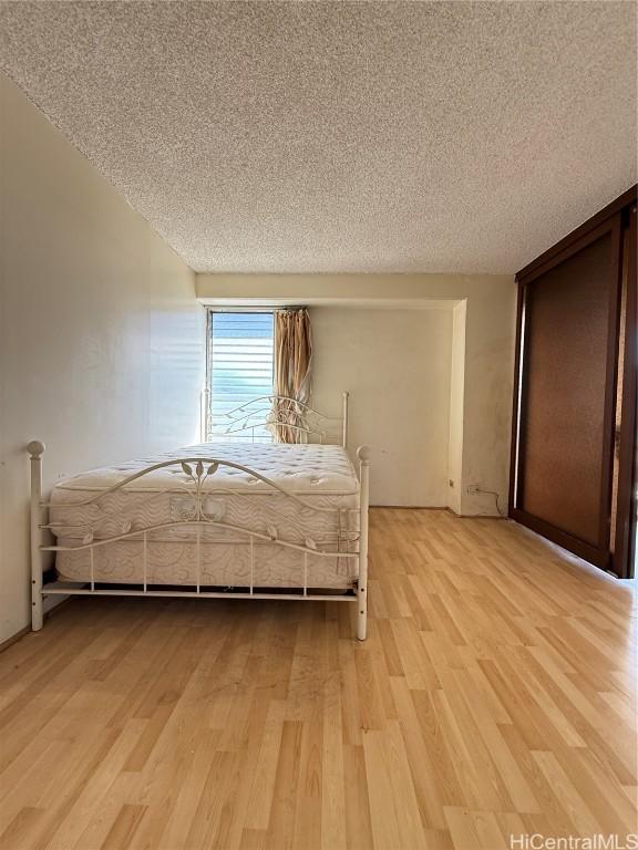 unfurnished bedroom featuring a textured ceiling and light wood-type flooring