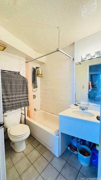 full bath featuring toilet, shower / tub combo with curtain, tile patterned flooring, a textured ceiling, and vanity