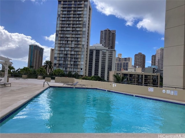 community pool with a patio area and a view of city