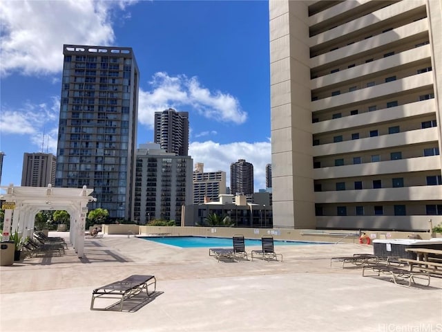 community pool featuring a pergola, a patio area, and a city view