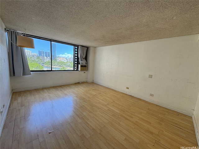 444 Niu St Unit 815, Honolulu, HI 96815 - spare room with wood finished floors, a textured ceiling, and baseboards
