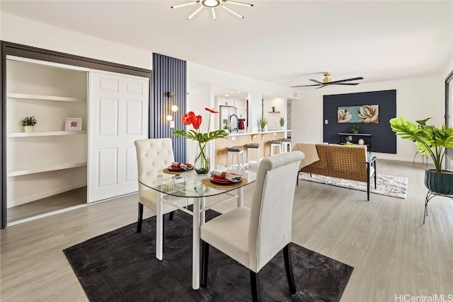 dining room featuring hardwood / wood-style flooring, ceiling fan, and sink