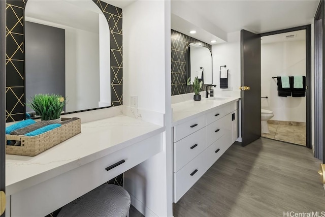 bathroom with vanity, wood-type flooring, and toilet