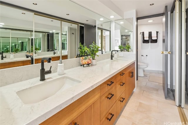 bathroom featuring recessed lighting, a sink, toilet, and double vanity