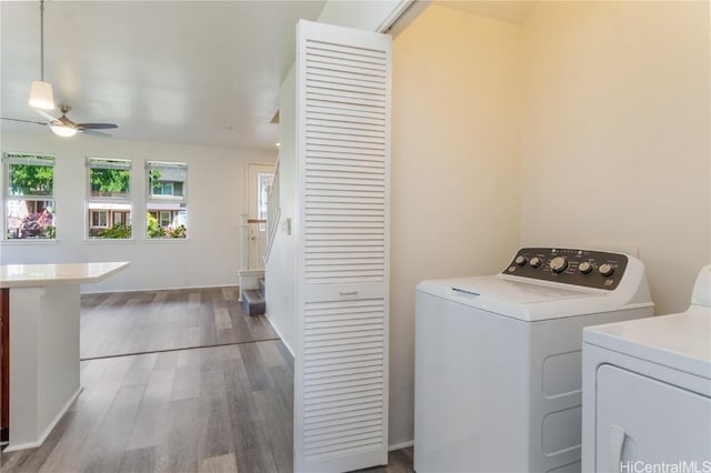 laundry area with laundry area, washer and clothes dryer, wood finished floors, and a ceiling fan