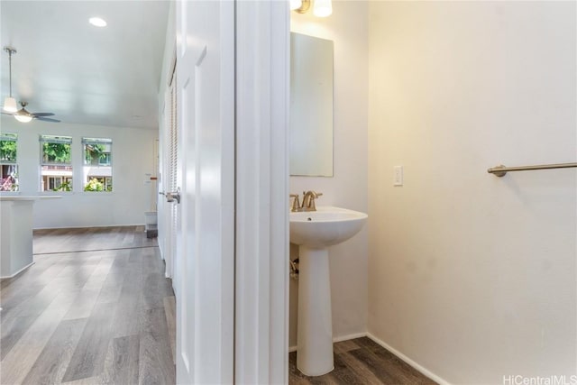 bathroom with a sink, ceiling fan, baseboards, and wood finished floors