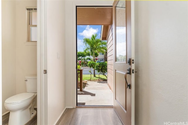 doorway featuring wood finished floors and baseboards