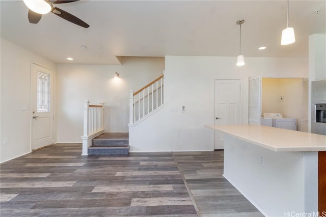 kitchen with recessed lighting, wood finished floors, light countertops, hanging light fixtures, and washer and clothes dryer