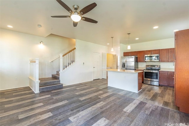 kitchen with a center island, dark wood-style flooring, pendant lighting, light countertops, and appliances with stainless steel finishes