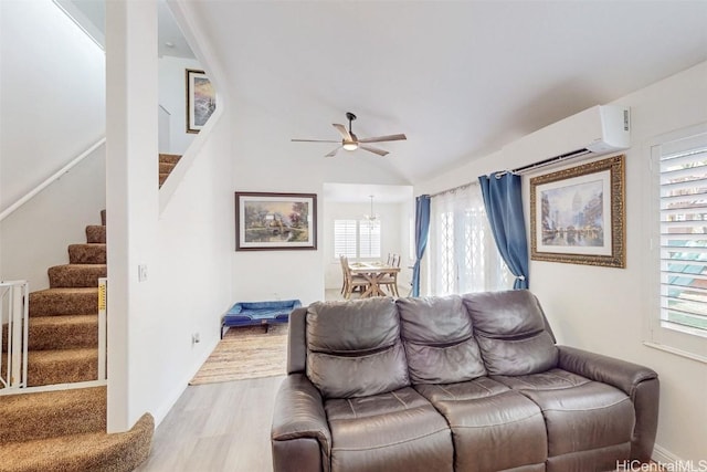 living room with a wall unit AC, stairs, a wealth of natural light, and wood finished floors