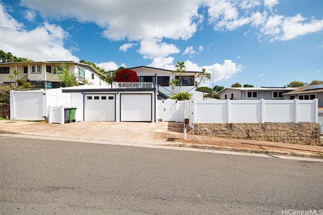 view of front facade featuring a residential view, a gate, fence, and driveway