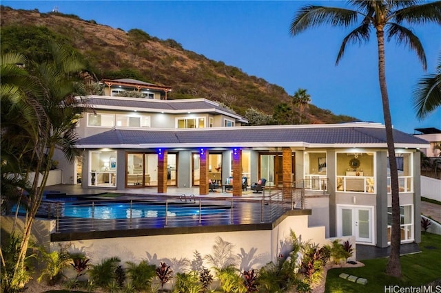 back of property with french doors, a mountain view, and a patio area