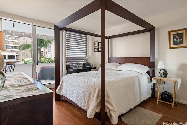 bedroom with dark hardwood / wood-style floors and access to exterior