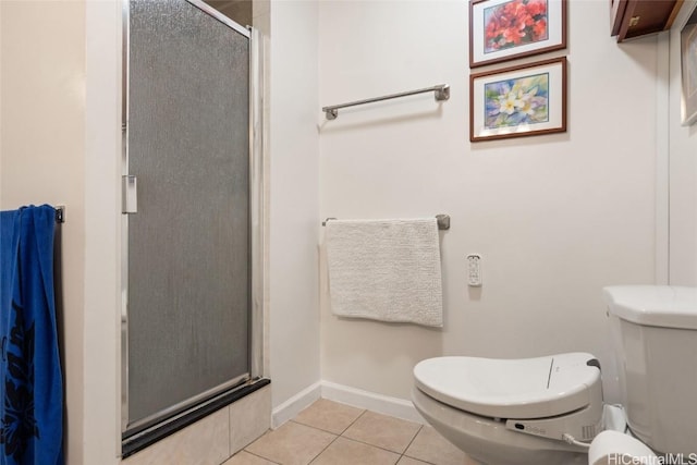 bathroom featuring tile patterned floors, toilet, and a shower with door