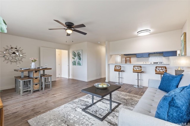 living room with hardwood / wood-style flooring and ceiling fan