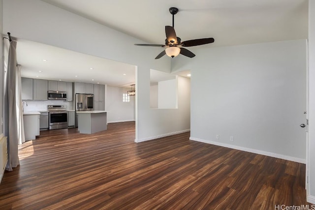 unfurnished living room with ceiling fan, lofted ceiling, sink, and dark hardwood / wood-style flooring