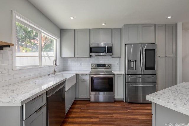 kitchen featuring stainless steel appliances, dark hardwood / wood-style flooring, gray cabinets, and sink