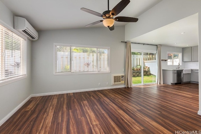 unfurnished living room with vaulted ceiling, dark hardwood / wood-style floors, sink, a wall mounted AC, and ceiling fan