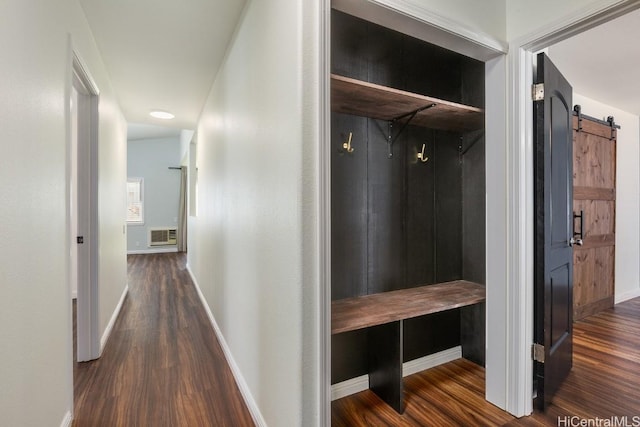 hallway with dark hardwood / wood-style floors and a barn door