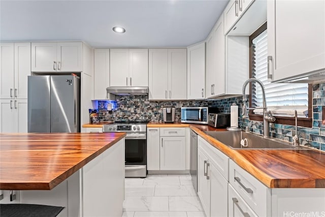 kitchen featuring white cabinets, appliances with stainless steel finishes, sink, and wooden counters